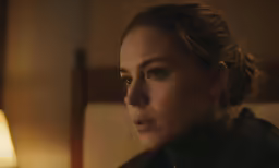 a young woman staring at something with a slight smile