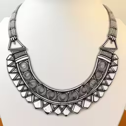 an unusual collar necklace is featured on a mannequin,a large metal necklace is on display,a necklace on a stand is displayed,a black and white collar necklace sits on a white dummy,a necklace on display with one of the beads removed