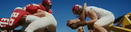 two football players holding their helmets with their hands together