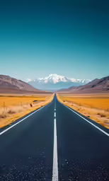 long straight road with mountains in background on a clear day