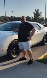 a man standing next to a car in the parking lot