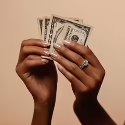 a person holds their hand up to show their money