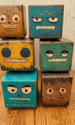 four boxes are made of wood and some have faces painted on them