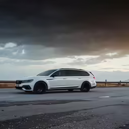 the white car is parked on a stormy highway