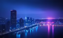 some tall buildings along a river at night