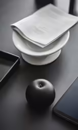 black tableware with phone, tablet and other items on top