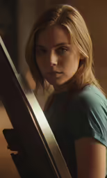 a girl wearing a blue shirt with long blonde hair