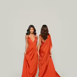 two women in long dresses standing side by side