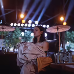 the woman is sitting on a chair and wrapped up in a blanket