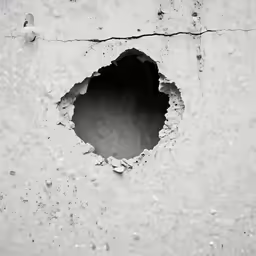a hole is visible in the side of a cement wall
