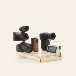 an old book has three cameras next to it