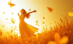 a woman in a long yellow dress flies across a field