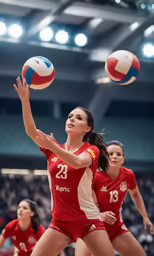 women wearing red uniforms playing volleyball in an arena