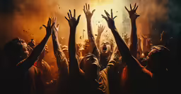 many people standing together holding their hands up in the air