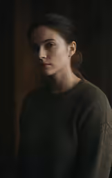 a girl in a green sweater standing up