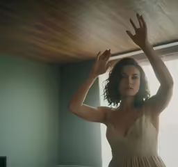 a woman is sitting at the end of a bed