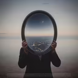 a man holds a mirror over his face as it is reflected in the glass