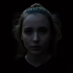 the dark portrait of a young girl with blonde hair