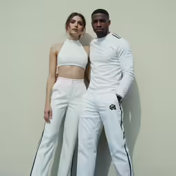 the man and woman are standing next to each other wearing white clothing