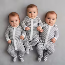 three baby boys dressed in striped onesuits