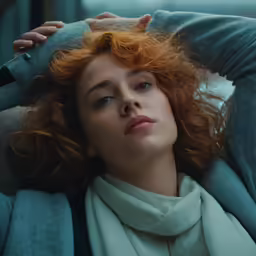 a close up of a person with red hair wearing scarf