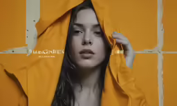 a beautiful woman sitting under a yellow blanket