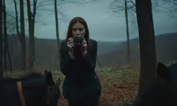 a young woman is taking a photograph of horses