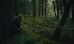 a woman is sitting by a tree and staring into the distance