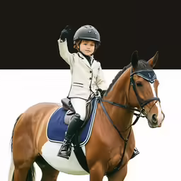 a little girl riding a horse in a race uniform