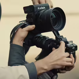 man with camera holding on to his arm