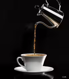 a cup of coffee being poured into it