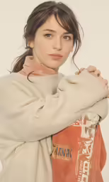 a young girl wearing a sweater posing for a picture