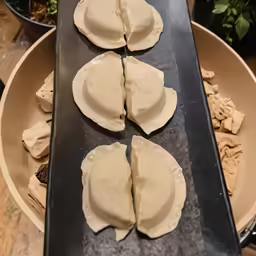 a tray filled with uncooked dough next to some pots and bowls