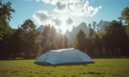 a camping tent is in a field by some trees