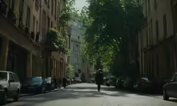 a man walking down a street between two buildings
