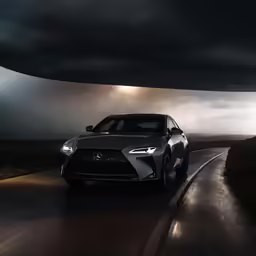 a car driving down the road under a cloudy sky