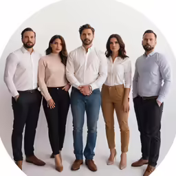 group of people posing in front of a white background