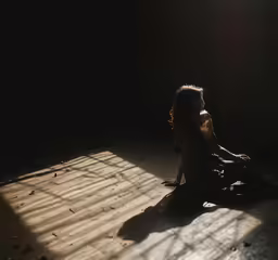 a woman sits in the shadow of her shadow light