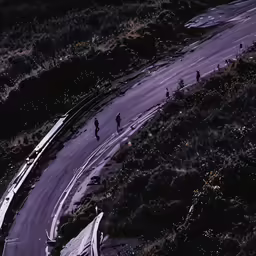 an aerial view of some motorcycles on a winding road