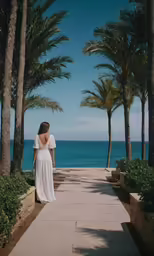 a woman wearing a dress looking at the ocean