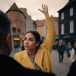 a woman waving at someone at an outdoor event