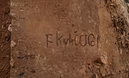 the word khlutch written on a mud wall