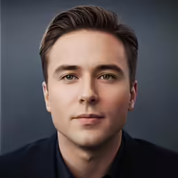 a man wearing a shirt and tie looking straight ahead
