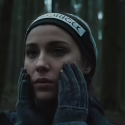 woman wearing a winter hat holding her hands up to her face