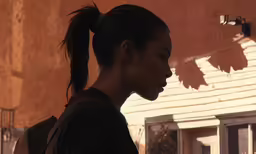 a woman with a ponytail standing in front of a building