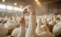 a person in a white shirt and white sleeves holding up a key