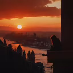 a person looking over a city at sunset