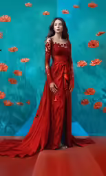 a beautiful red dress in front of a flower wall