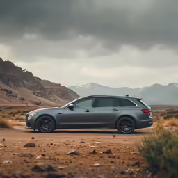 a gray suv driving down a dirt road