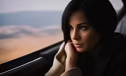 there is a young woman sitting in the car looking out the window
